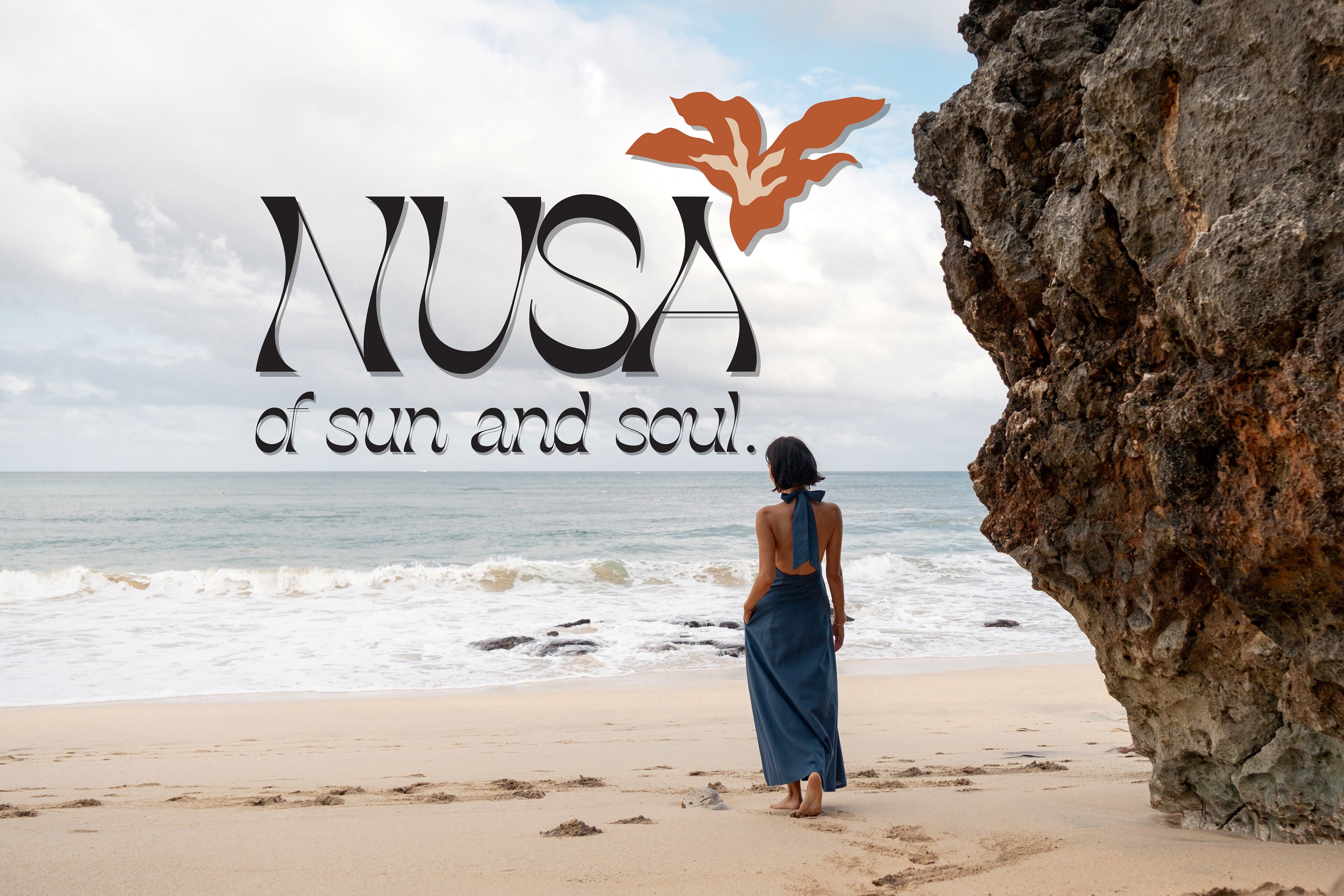 Woman standing on a beach with a large rock and ocean view, featuring the NUSA collection logo.
